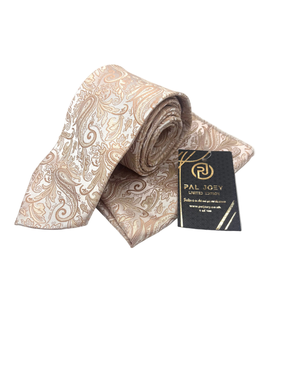 A rolled and flat-laid beige and brown paisley silk necktie with a black brand tag that reads 'PAL TOXY LIMITED MANUFACTURING'.